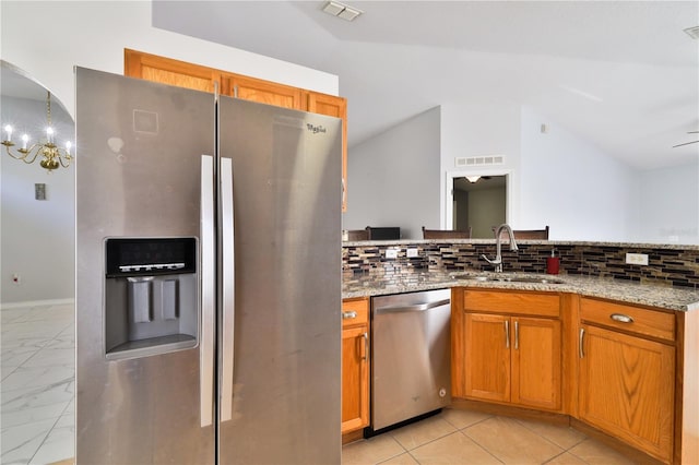 kitchen featuring a notable chandelier, backsplash, sink, and stainless steel appliances