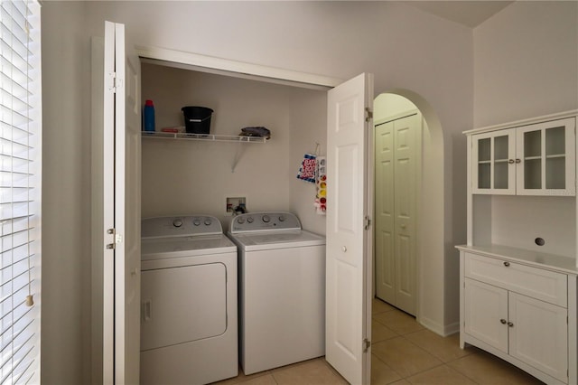 laundry room featuring washer hookup, plenty of natural light, washing machine and clothes dryer, and light tile flooring