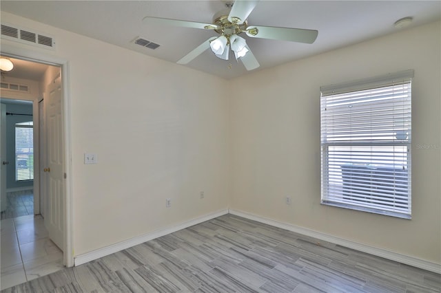 tiled spare room featuring ceiling fan and a healthy amount of sunlight