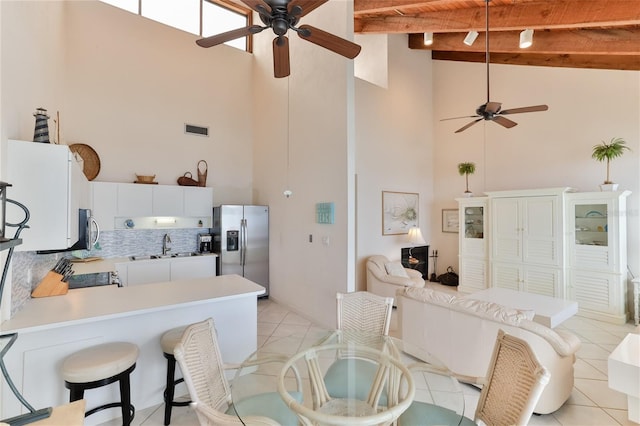 4875 S Atlantic Ave Unit E, New Smyrna Beach, FL 32169 - kitchen featuring backsplash, high vaulted ceiling, stainless steel appliances, and beamed ceiling