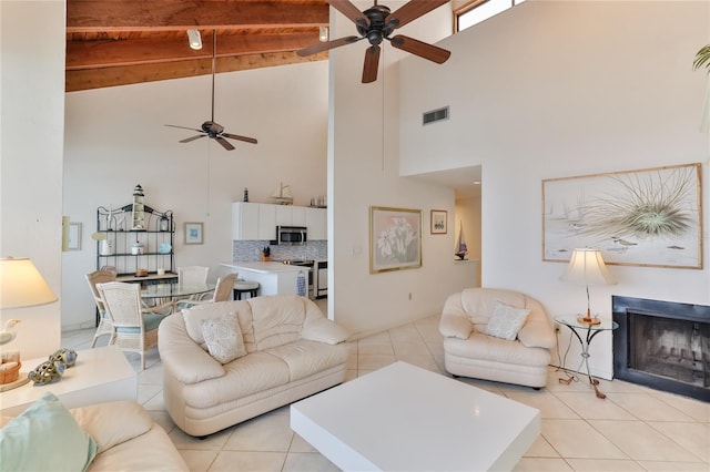 4875 S Atlantic Ave Unit E, New Smyrna Beach, FL 32169 - living room with light tile floors, a high ceiling, ceiling fan, and beam ceiling