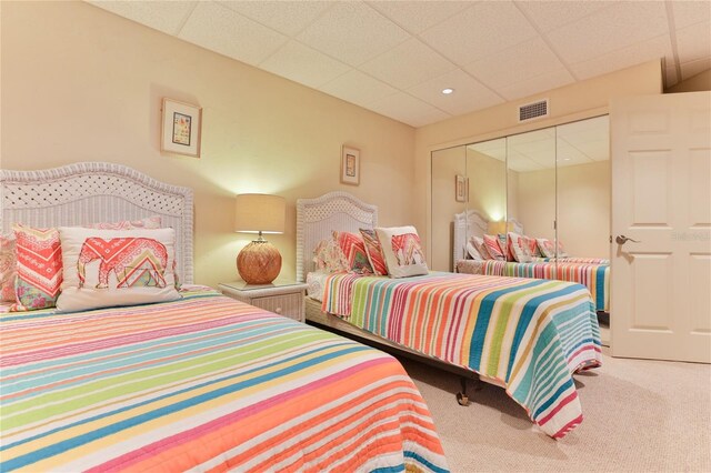 4875 S Atlantic Ave Unit E, New Smyrna Beach, FL 32169 - bedroom with light carpet, a closet, and a paneled ceiling