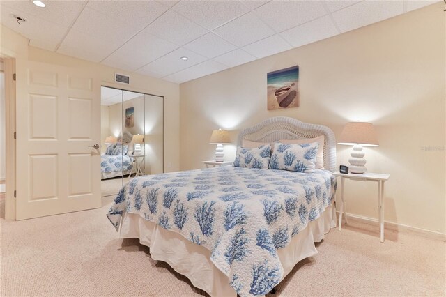 4875 S Atlantic Ave Unit E, New Smyrna Beach, FL 32169 - bedroom featuring a closet, a drop ceiling, and light colored carpet