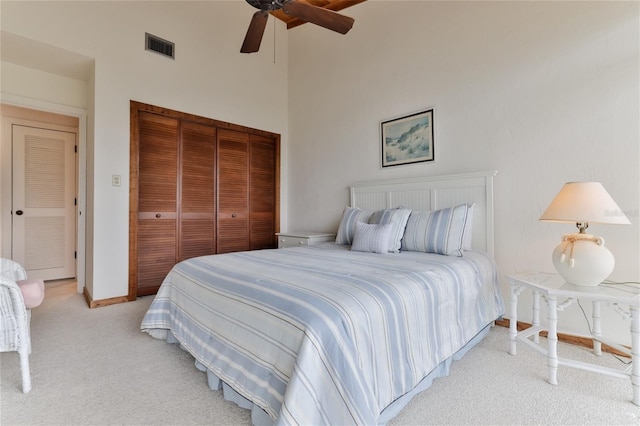 4875 S Atlantic Ave Unit E, New Smyrna Beach, FL 32169 - bedroom featuring a closet, light carpet, ceiling fan, and a towering ceiling