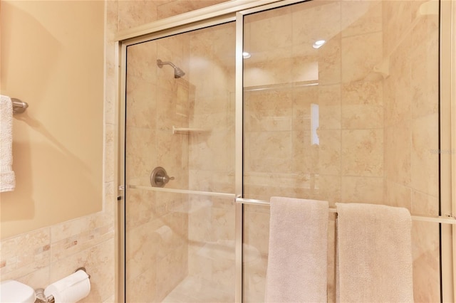4875 S Atlantic Ave Unit E, New Smyrna Beach, FL 32169 - bathroom featuring tile walls, toilet, and a shower with shower door