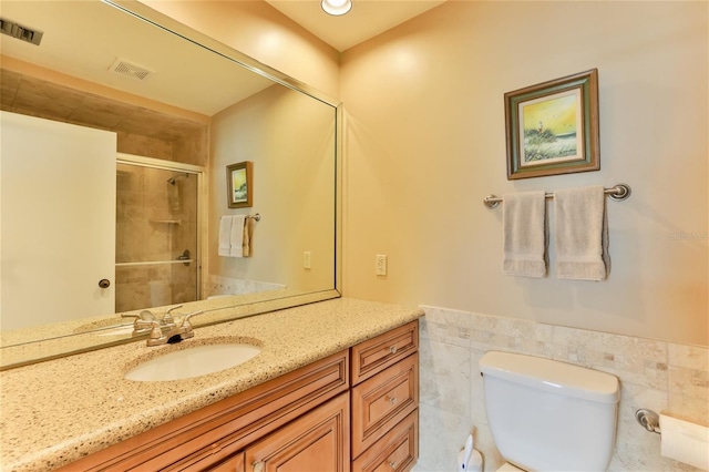 4875 S Atlantic Ave Unit E, New Smyrna Beach, FL 32169 - bathroom with tile walls, toilet, and vanity with extensive cabinet space