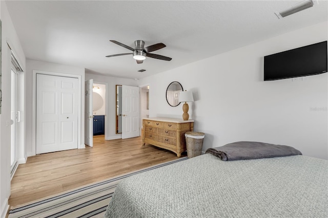 bedroom featuring a closet, ceiling fan, ensuite bathroom, and light wood-type flooring