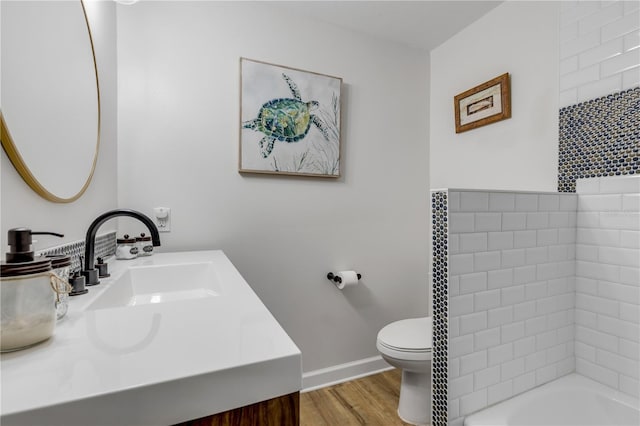 bathroom with oversized vanity, toilet, and wood-type flooring