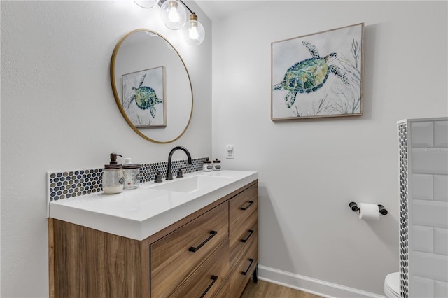 bathroom featuring oversized vanity, toilet, and hardwood / wood-style flooring