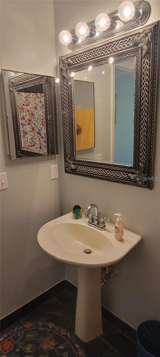 bathroom with baseboards, a sink, and tile patterned floors