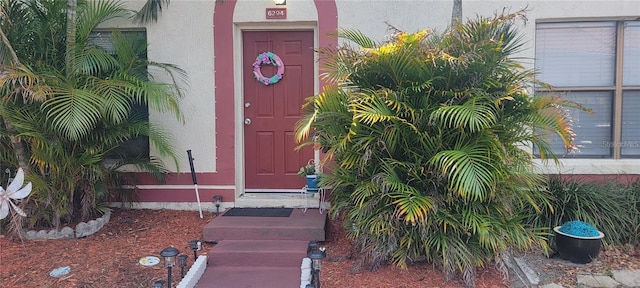 entrance to property featuring stucco siding