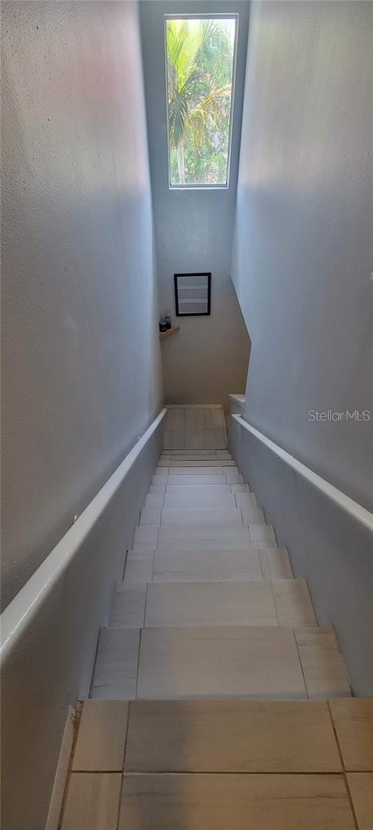 stairway with light tile floors