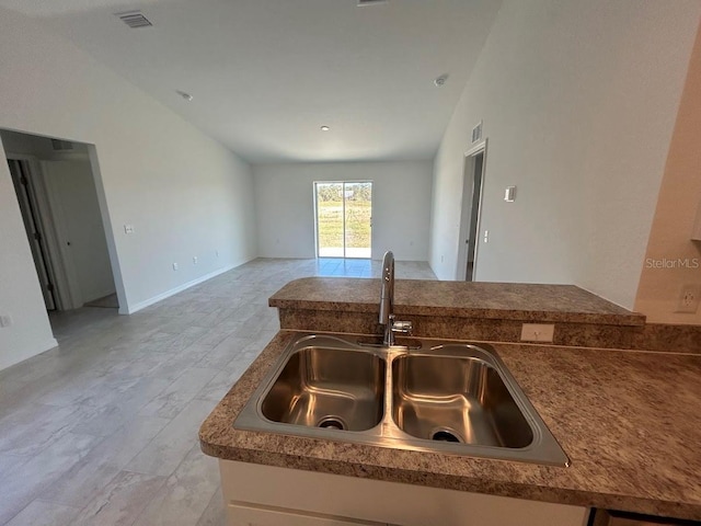 kitchen featuring vaulted ceiling and sink
