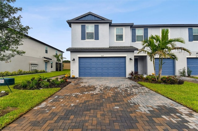 view of front of house with a garage, a front lawn, decorative driveway, and stucco siding