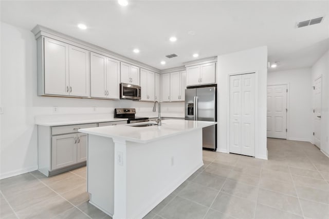 kitchen with light countertops, appliances with stainless steel finishes, a sink, and visible vents