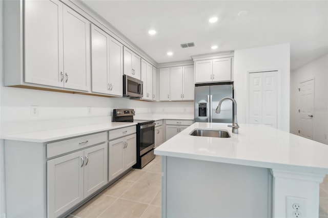 kitchen with appliances with stainless steel finishes, light countertops, visible vents, and a sink