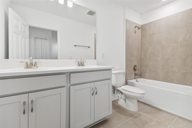 bathroom featuring double vanity, tile patterned flooring, a sink, and toilet