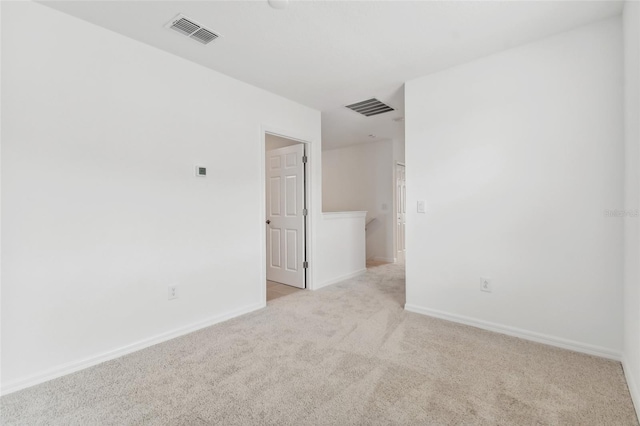 spare room featuring light carpet, baseboards, and visible vents