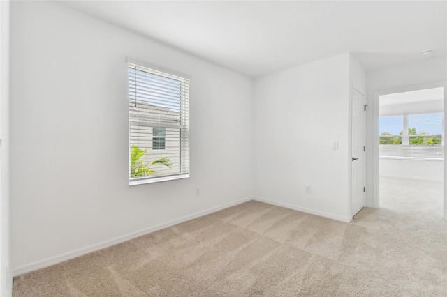 empty room with light carpet and baseboards