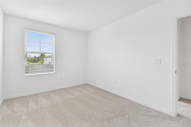 empty room featuring carpet and baseboards