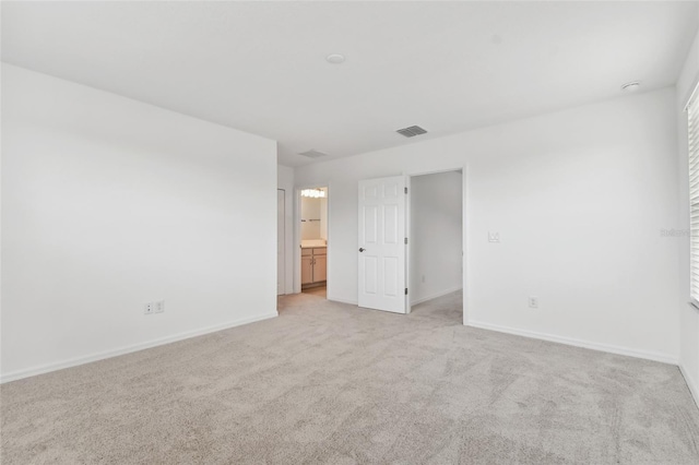 spare room with baseboards, visible vents, and light colored carpet