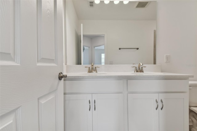 full bathroom with double vanity, a sink, and visible vents