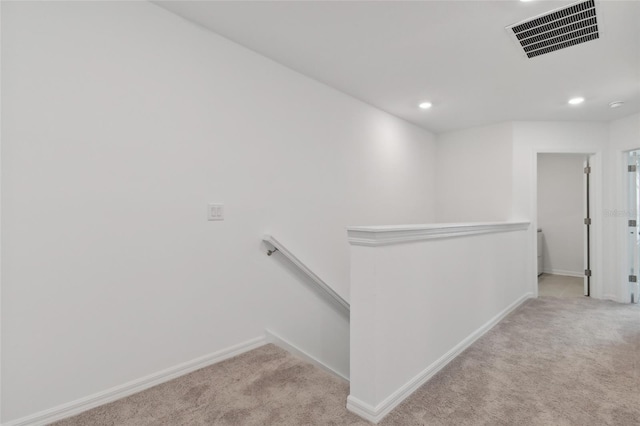 corridor with visible vents, carpet, an upstairs landing, and baseboards