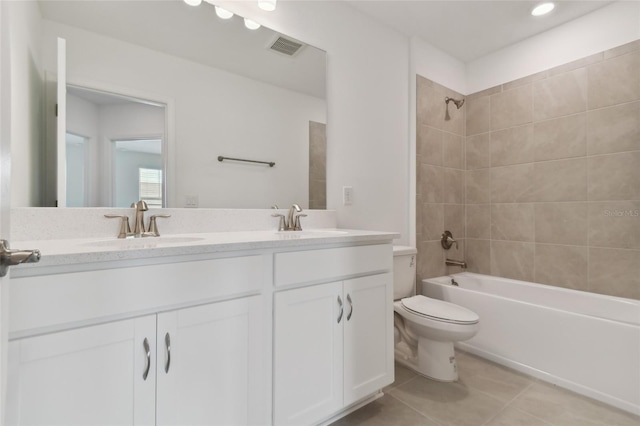 full bath featuring double vanity, shower / bathing tub combination, toilet, a sink, and tile patterned floors