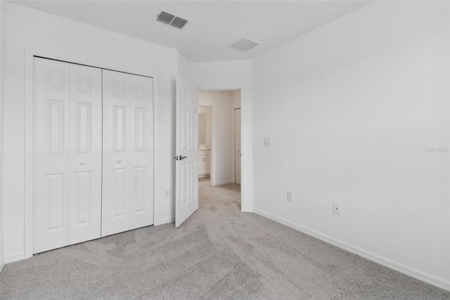 unfurnished bedroom featuring a closet, visible vents, baseboards, and carpet flooring