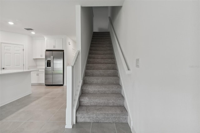 staircase featuring light tile patterned floors