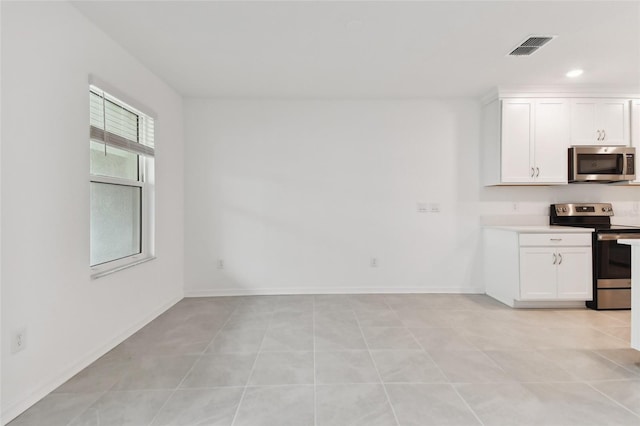 kitchen with baseboards, appliances with stainless steel finishes, visible vents, and white cabinets