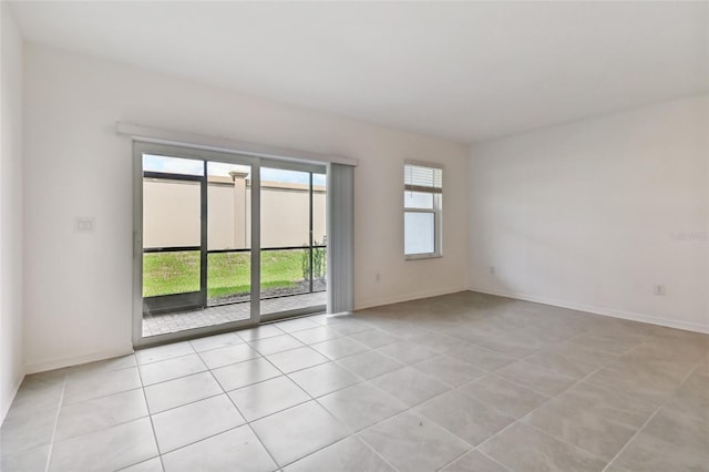 spare room with light tile patterned floors and baseboards