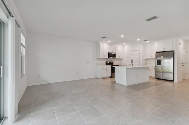 kitchen featuring white cabinets, visible vents, appliances with stainless steel finishes, and open floor plan