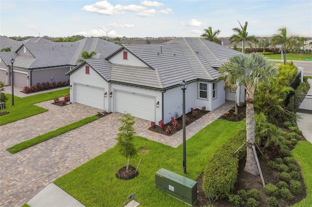 view of front of property with a front lawn, decorative driveway, a garage, and stucco siding