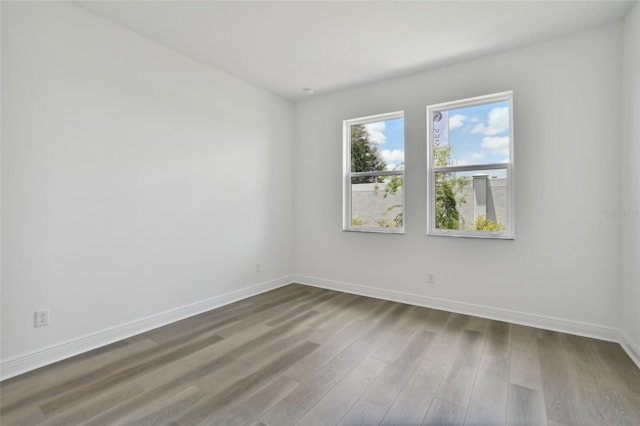 empty room featuring wood finished floors and baseboards