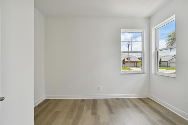 unfurnished room featuring light wood-style flooring and baseboards