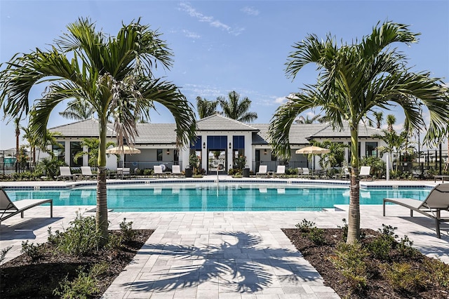 community pool with fence and a patio