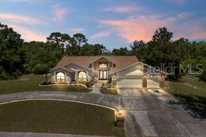 view of front of property featuring a lawn and a garage