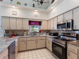 kitchen with decorative backsplash, appliances with stainless steel finishes, light brown cabinets, and light tile patterned floors