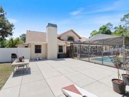 rear view of property with a patio area, a lanai, and a fenced in pool