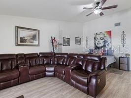 living room featuring light hardwood / wood-style flooring and ceiling fan