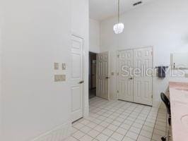 interior space featuring light tile patterned floors and decorative light fixtures