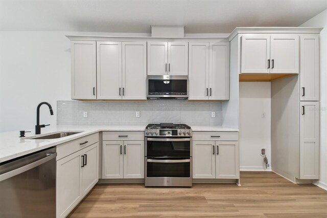 kitchen featuring appliances with stainless steel finishes, backsplash, and light hardwood / wood-style floors