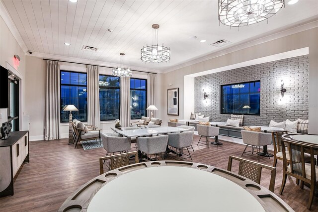 dining area featuring a notable chandelier, dark hardwood / wood-style floors, brick wall, and crown molding