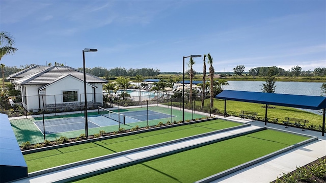 view of home's community with tennis court and a water view