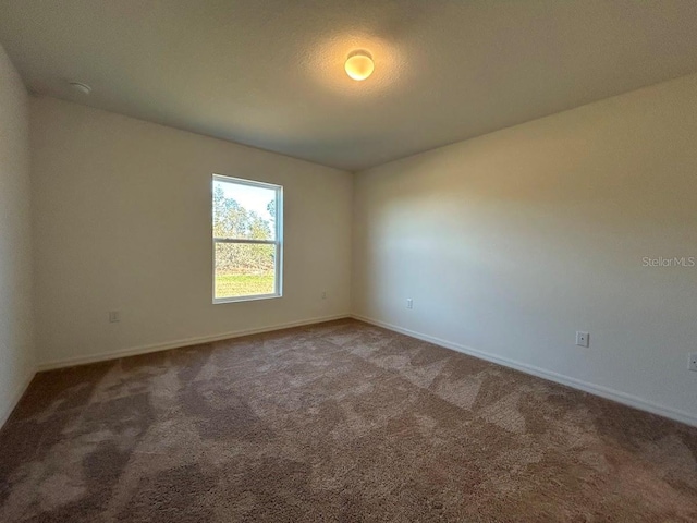 unfurnished room featuring carpet and a textured ceiling