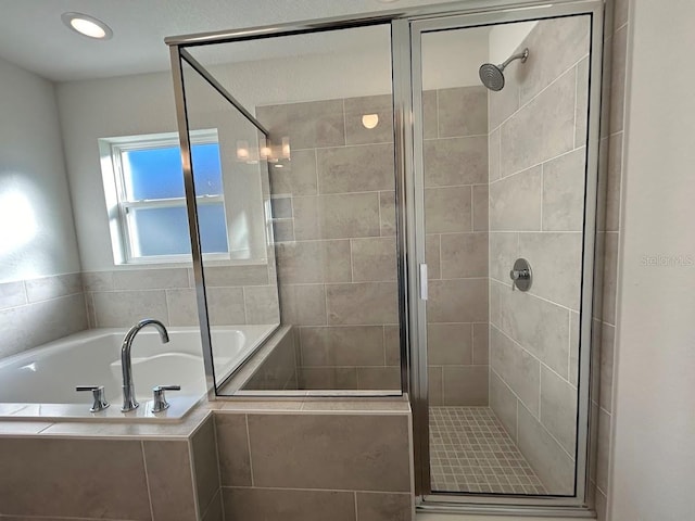 bathroom featuring shower with separate bathtub