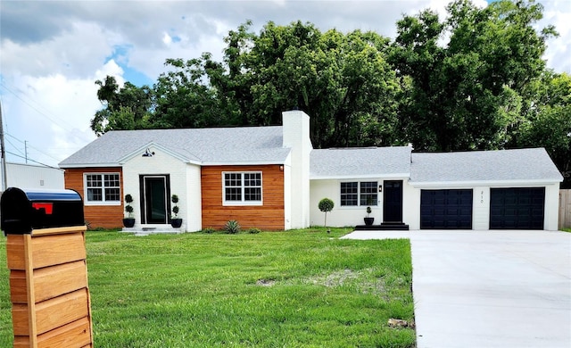 single story home with a front lawn, entry steps, concrete driveway, a chimney, and a garage