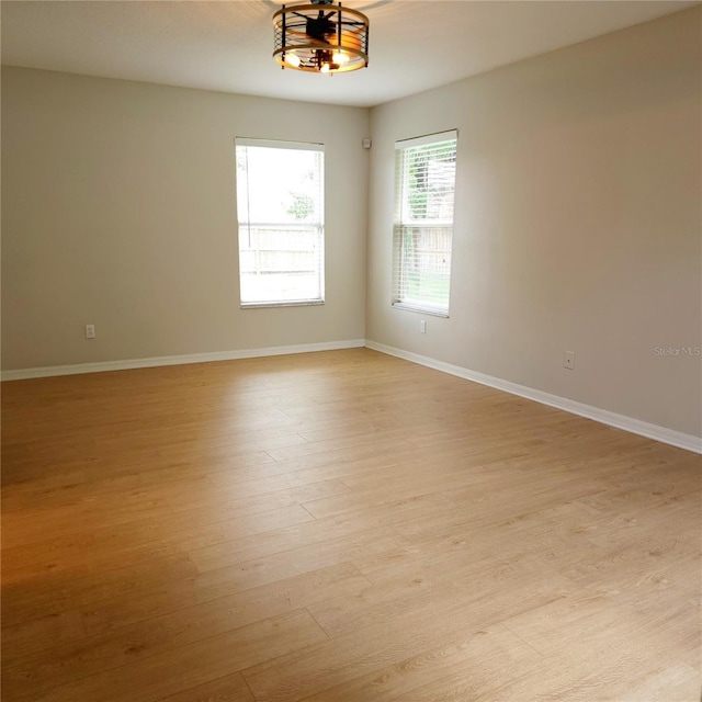 unfurnished room with baseboards and light wood finished floors