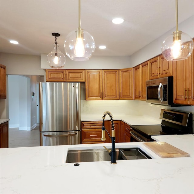 kitchen featuring hanging light fixtures, sink, appliances with stainless steel finishes, and tasteful backsplash